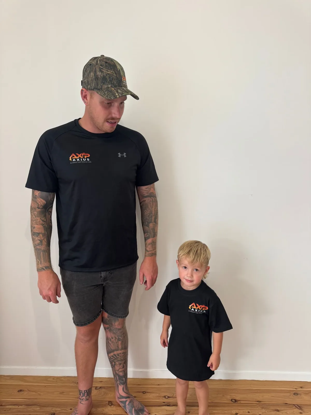 Connor, owner of Axius Plumbing, with his son in branded workwear