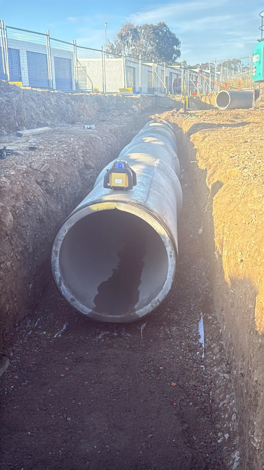 Large concrete pipe sections laid in an excavated trench