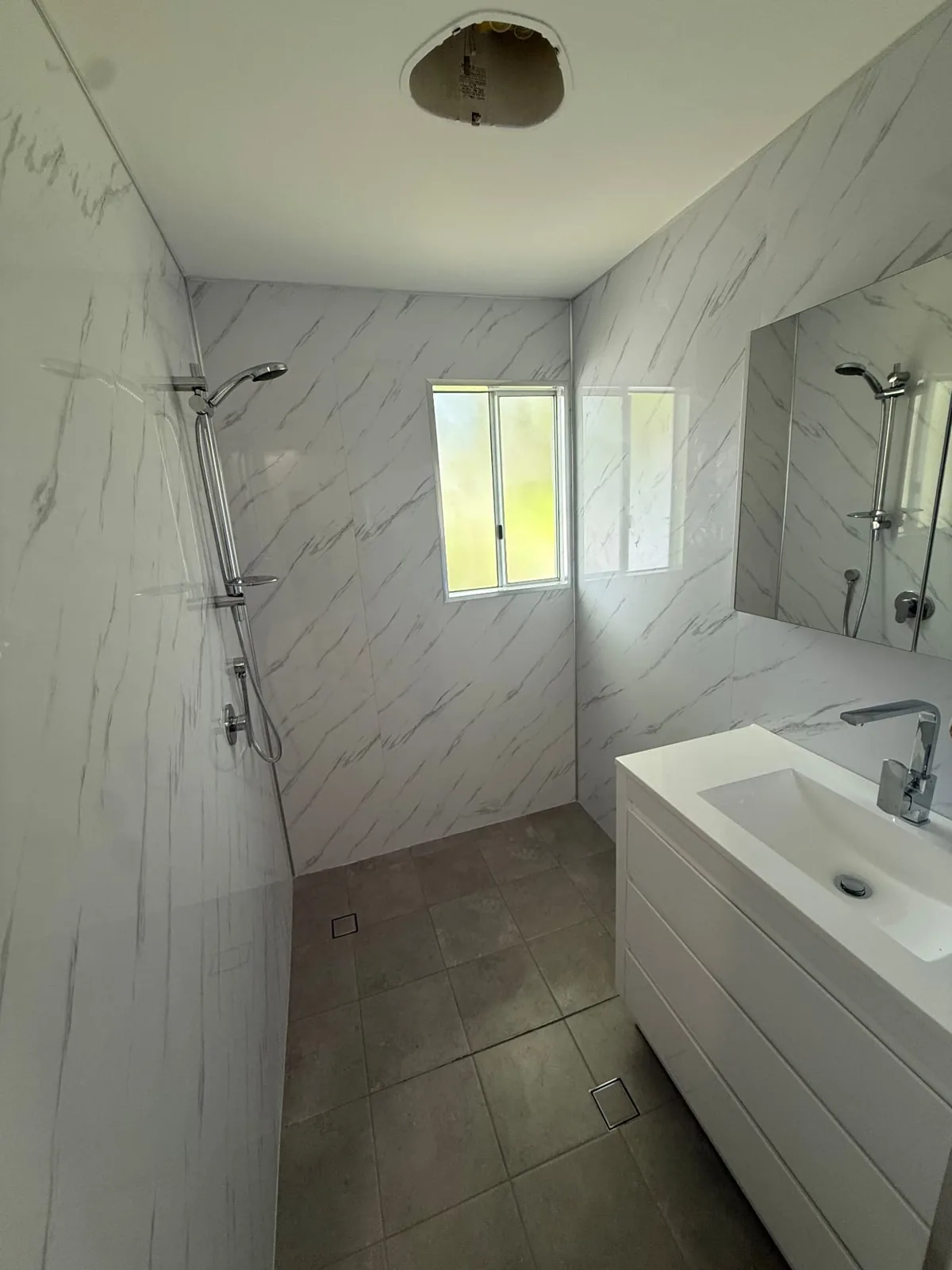 Glass shower screen, wall-hung vanity and light wall tiles